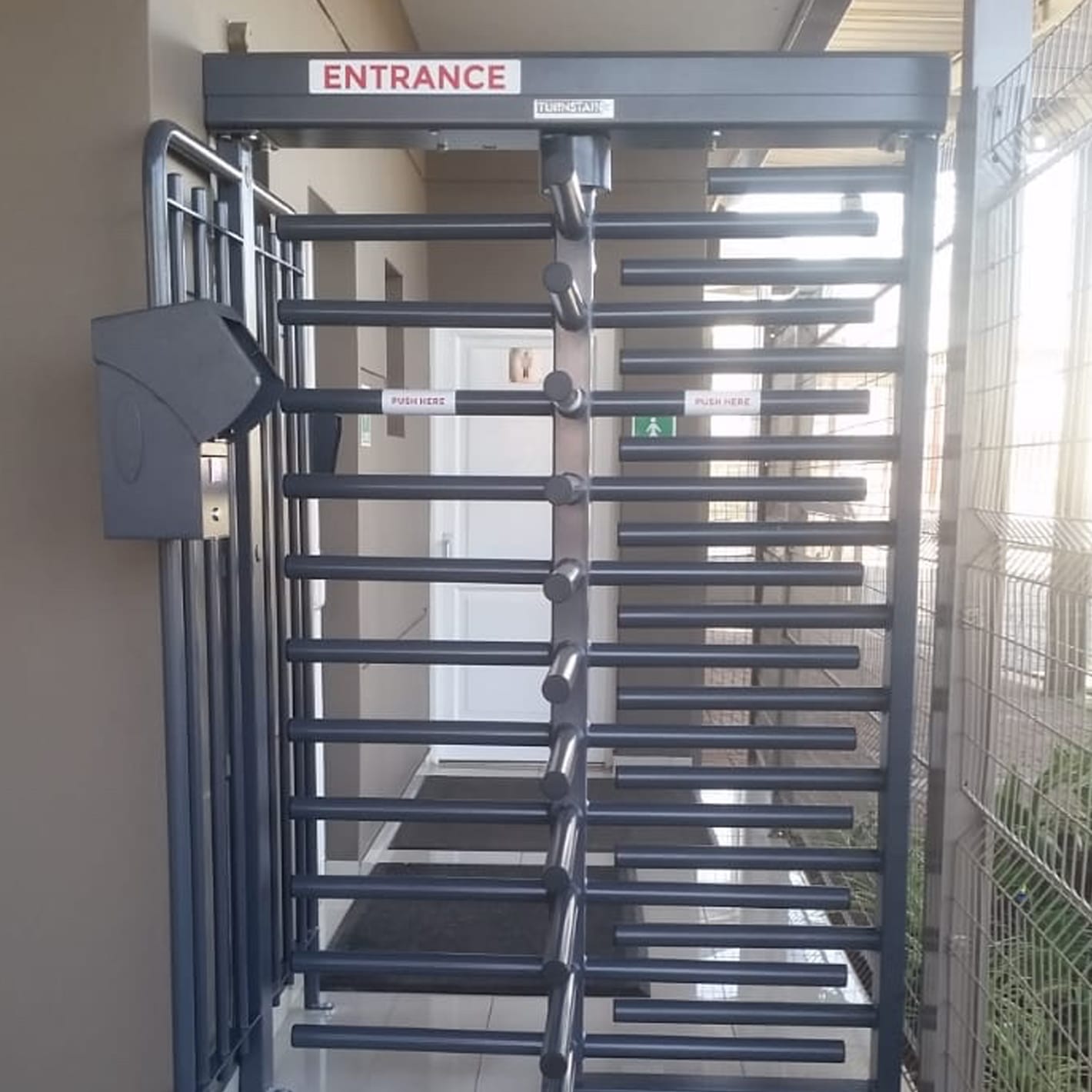 Full-height turnstile with a coin acceptor installed in an entrance passage.
