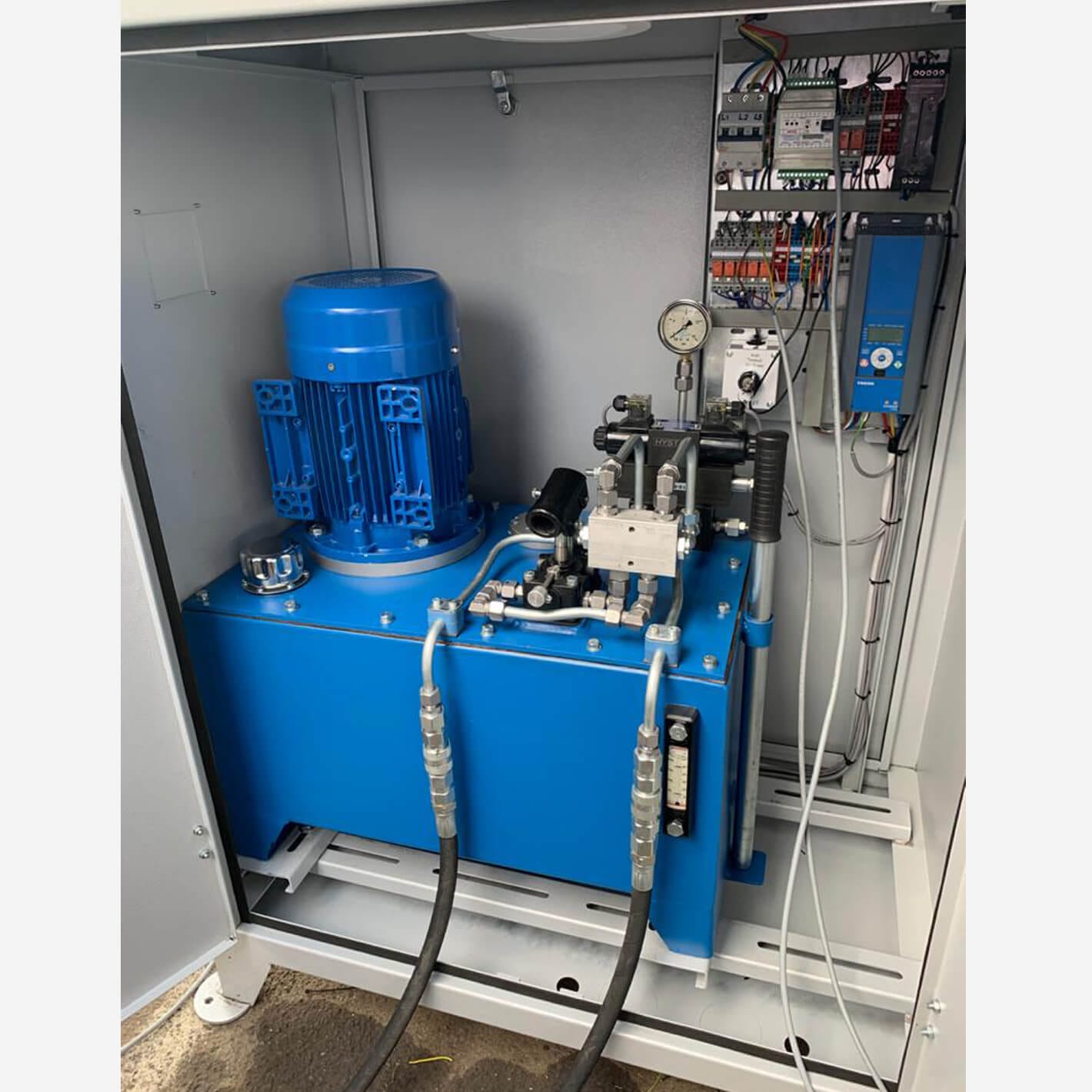 Blue hydraulic power pack and control panel inside the Shield power pack cabinet.