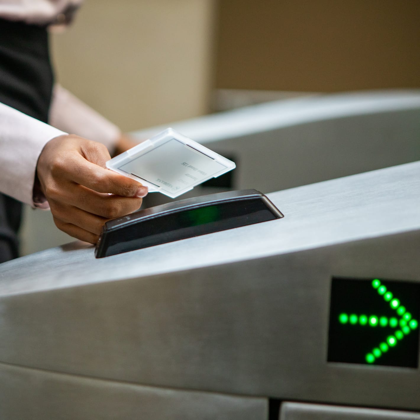 Close-up of a card being held to the reader with a green arrow on the Speedgate Express.