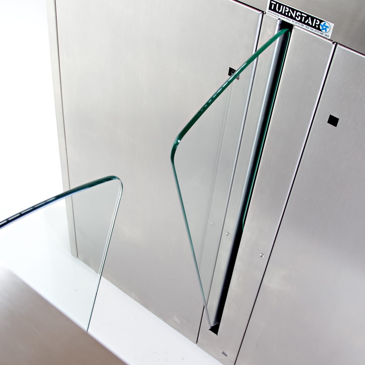 Close-up of curved glass wings retracting into a brushed stainless steel Speedgate Motion cabinet.