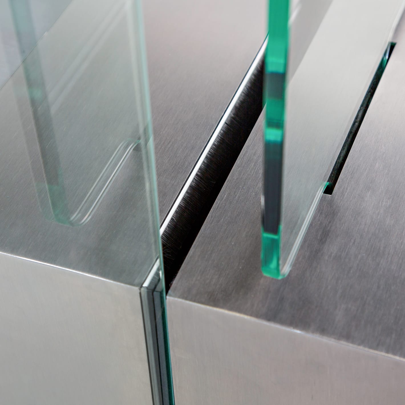 Close-up of the toughened glass wings sliding into the brushed stainless steel cabinet.