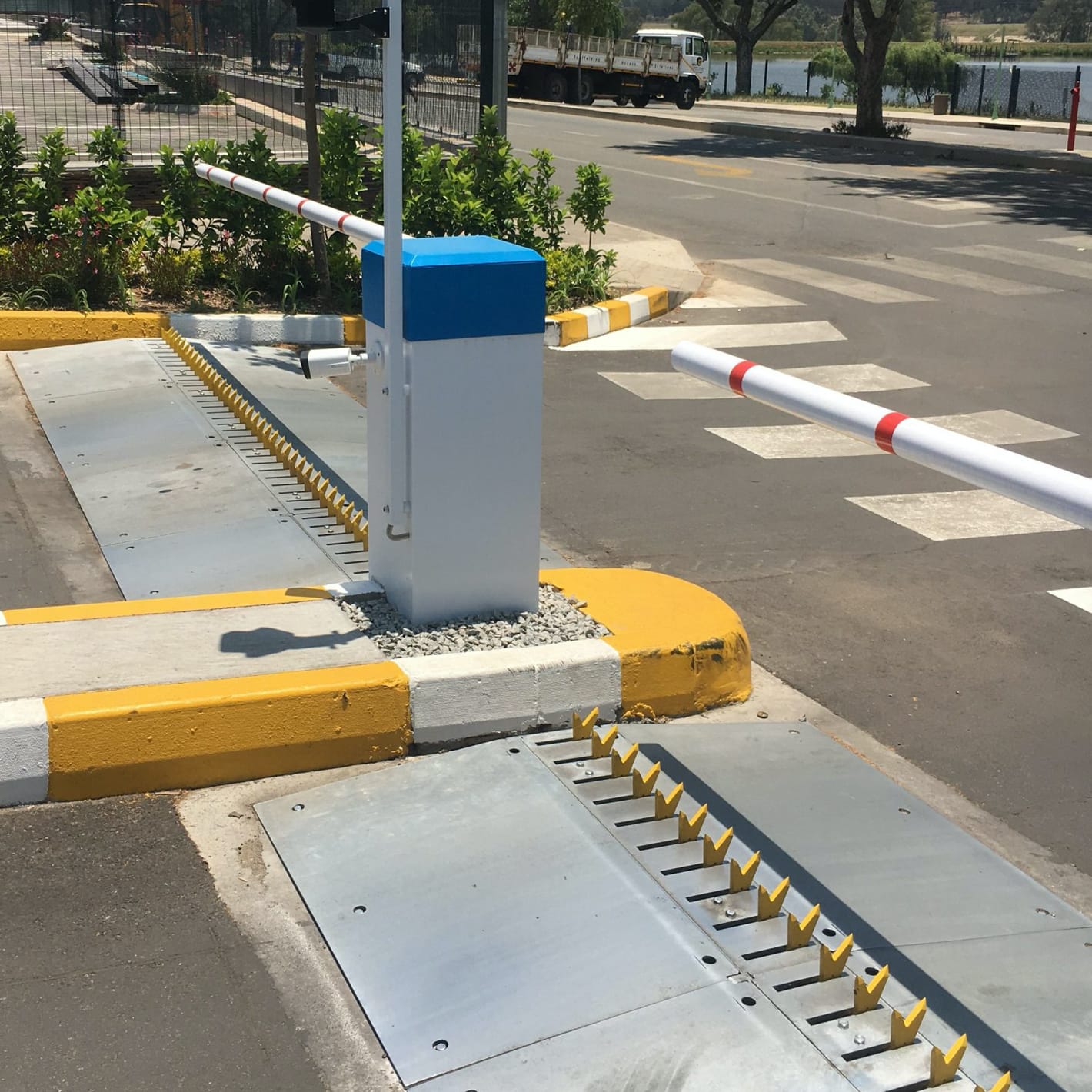Recessed Talon spike rack set into the road beside a barrier on a kerbed island.