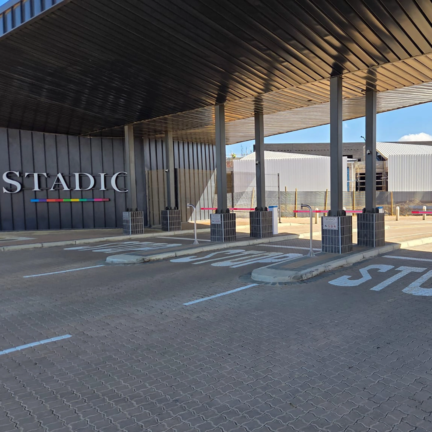 Velocity Nitro barriers in the entry lanes under a canopy at a campus gatehouse.
