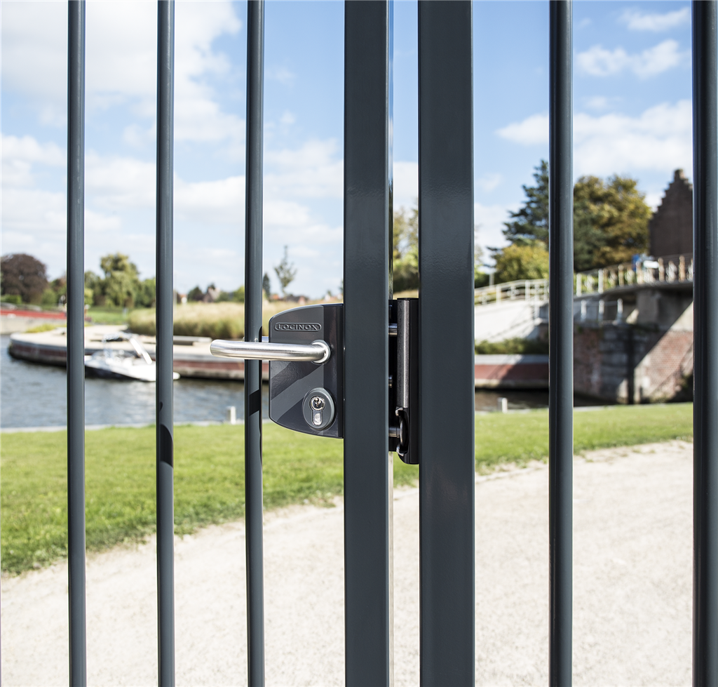 Black Locinox gate lock on a vertical bar gate by the water