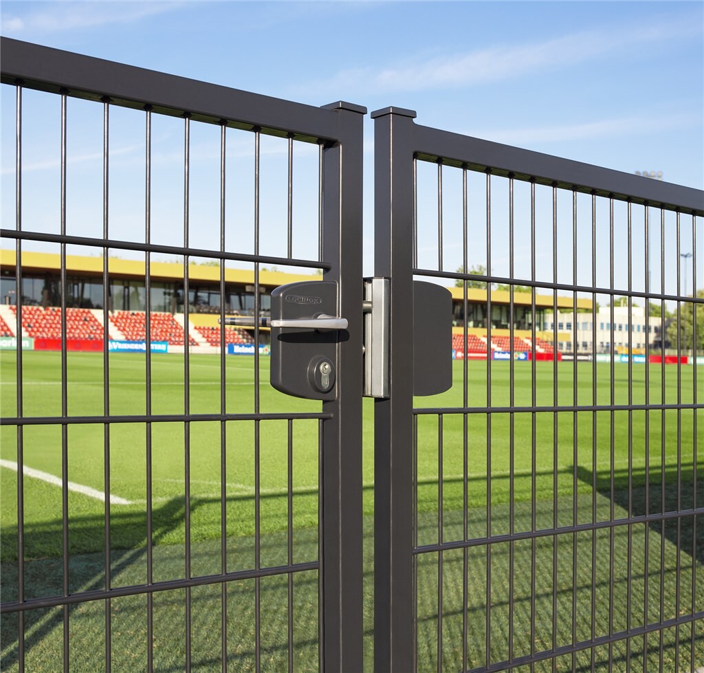 Black Locinox gate lock on a mesh gate at a sports ground
