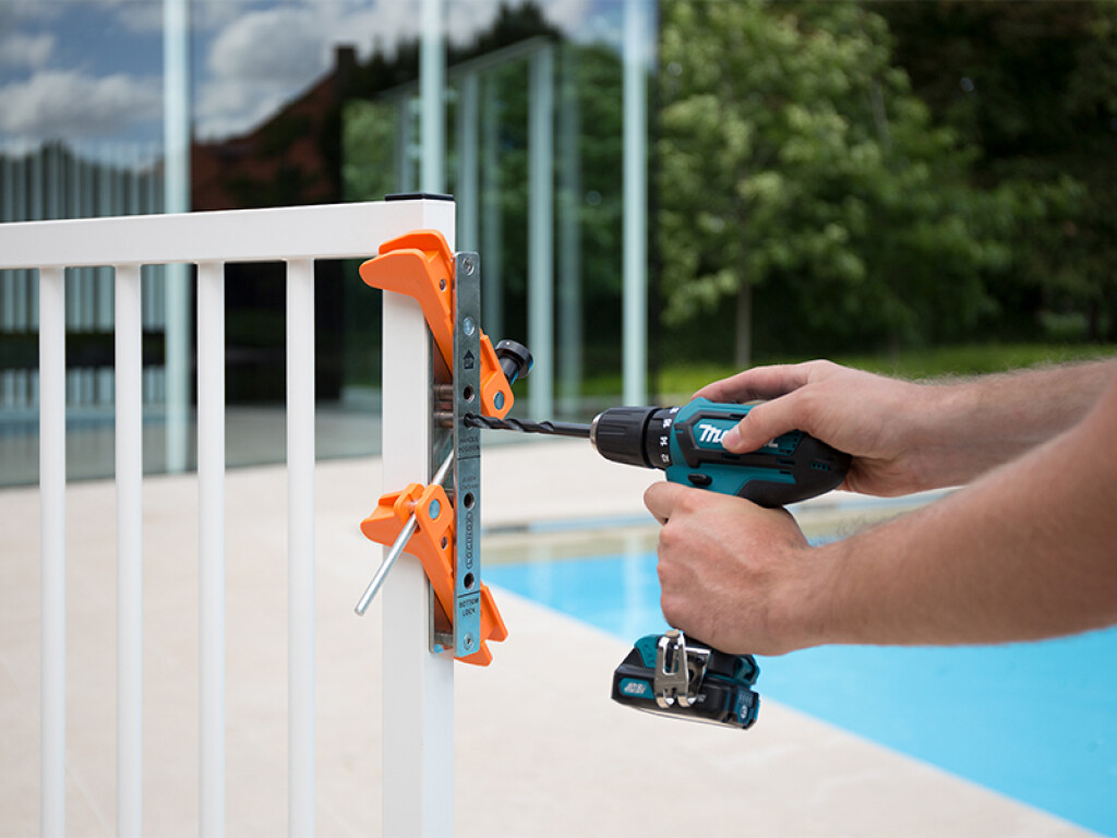 Drilling a gate profile with the Locinox Drill-Fix jig at a pool fence