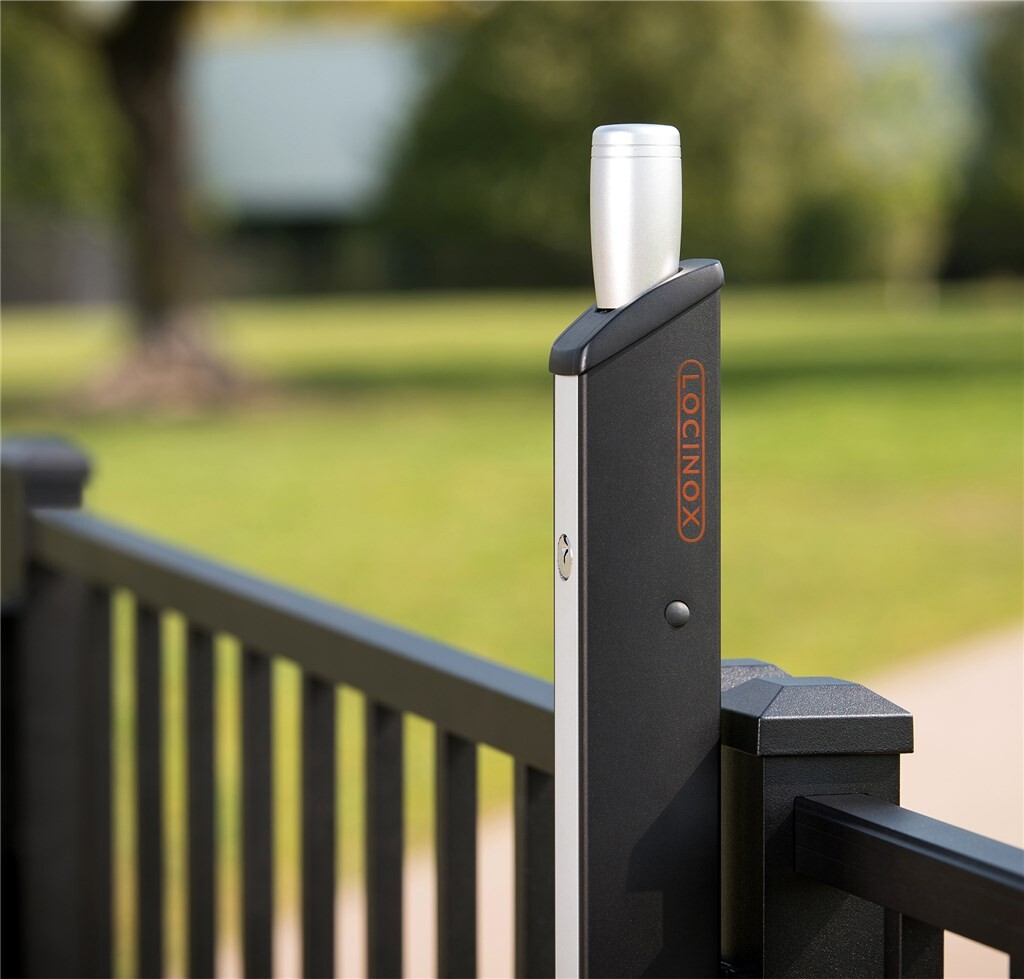 Locinox Fortima latch on a black square gate post beside a lawn