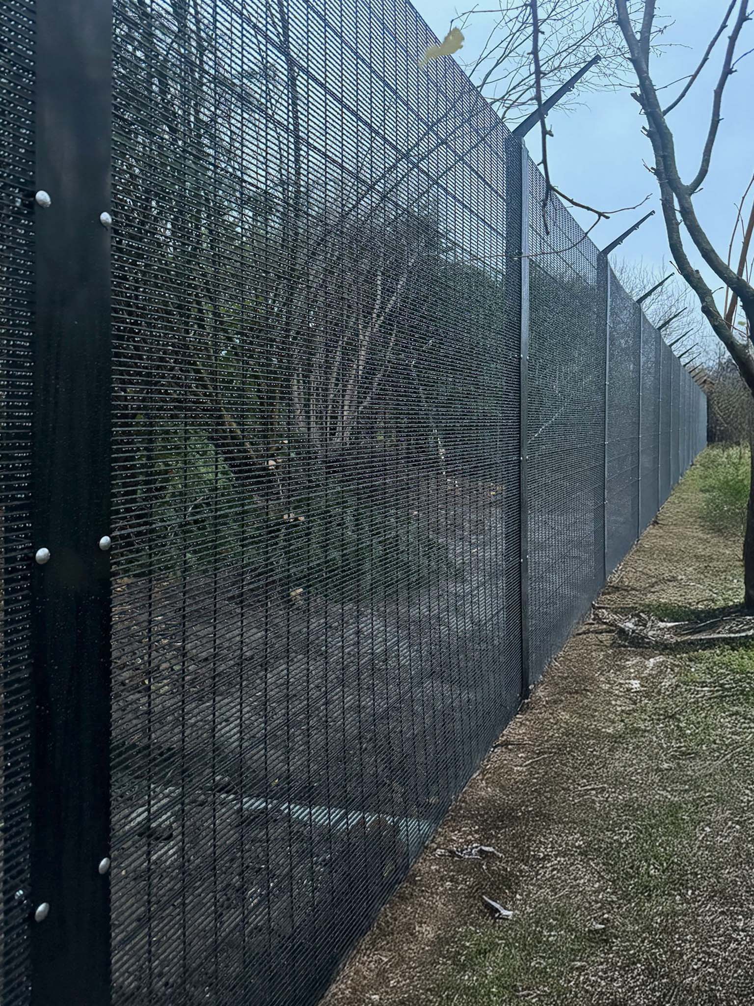 High security fence with cover plate and a barbed topping